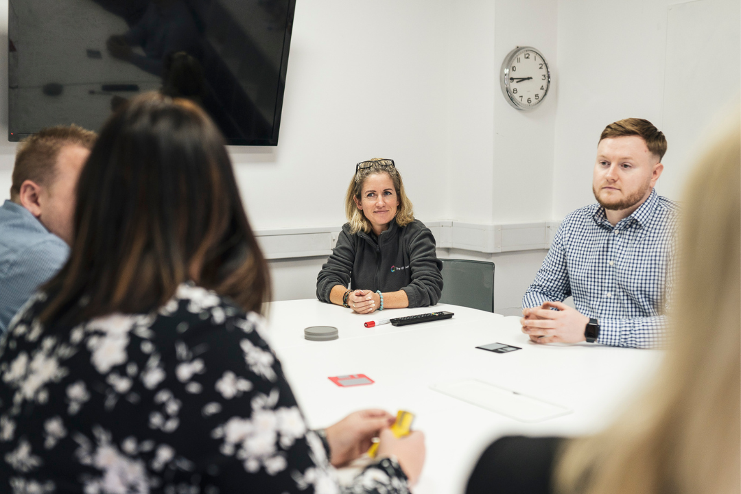 4 people in meeting at table