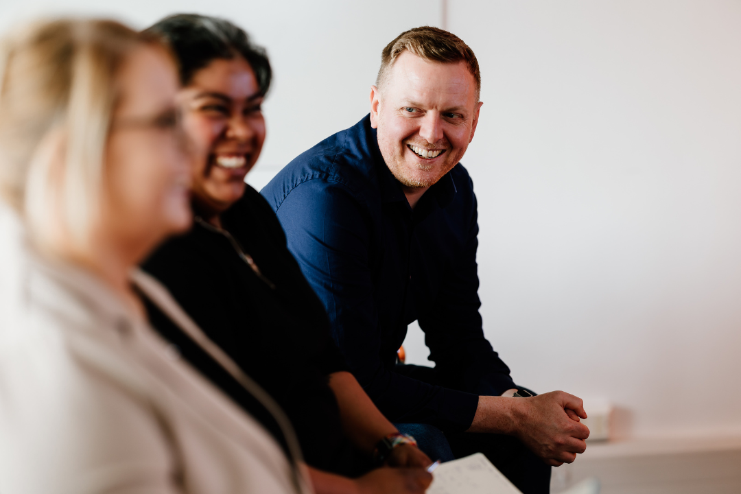 Three people sat in meeting