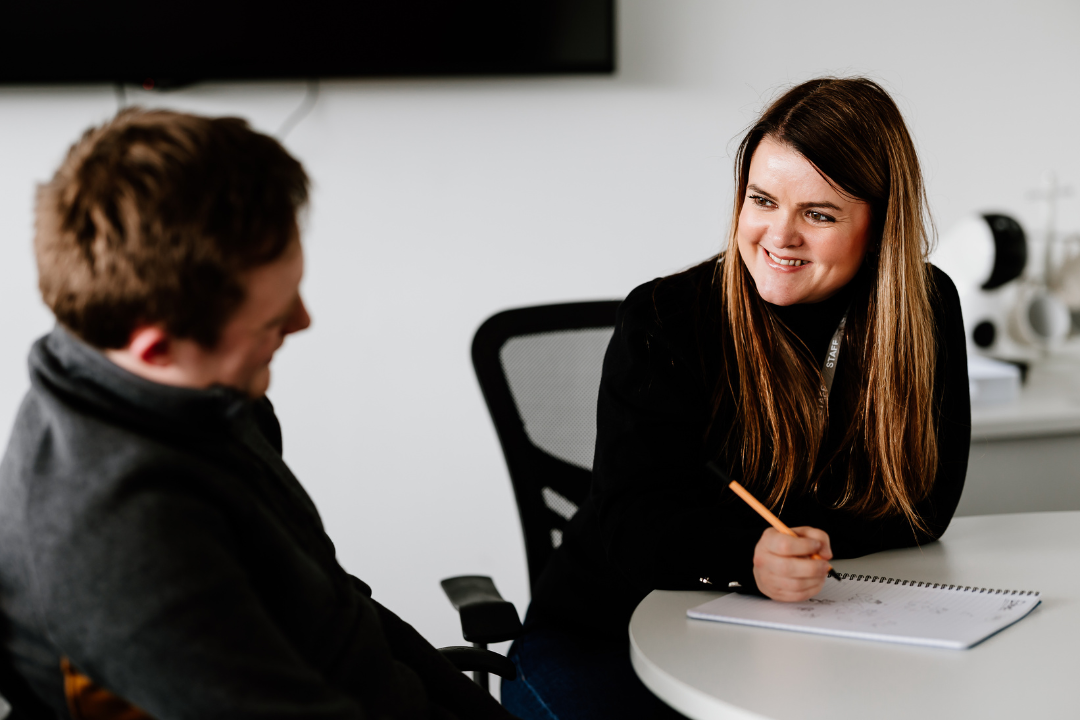 Woman and Man Smiling Sat at Table