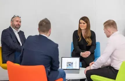 Business-Continuity-Planning-Four-People-Sat-on-Colourful-Chairs-in-Meeting-with-Laptop-on-Table-430x280